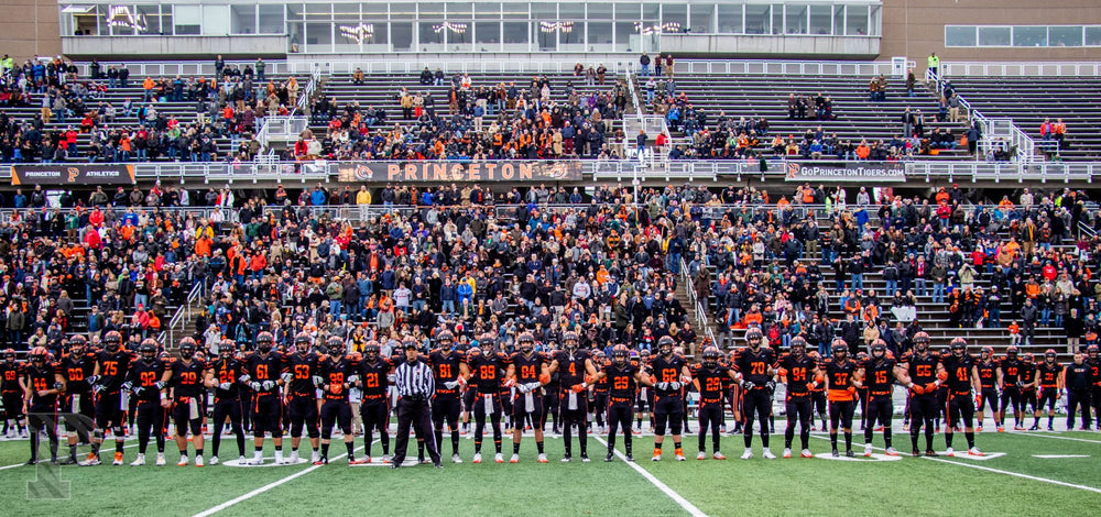 The Princeton football team lined up arm in arm on the field before a game