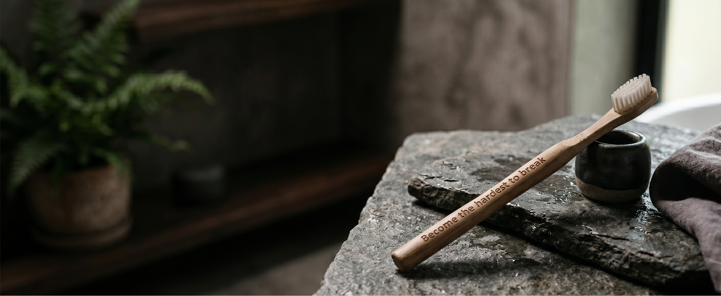toothly bamboo toothbrush on a stone surface 